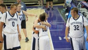 Members of the Unified Team hugging on the basketball court.
