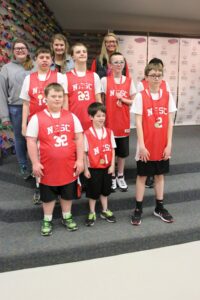 Tate and friends posing on basketball court.